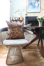 Load image into Gallery viewer, Batik and mudcloth textile home goods in modern Boho home, pillows made in Tanzania on Platner chair. African art and monstera plant.
