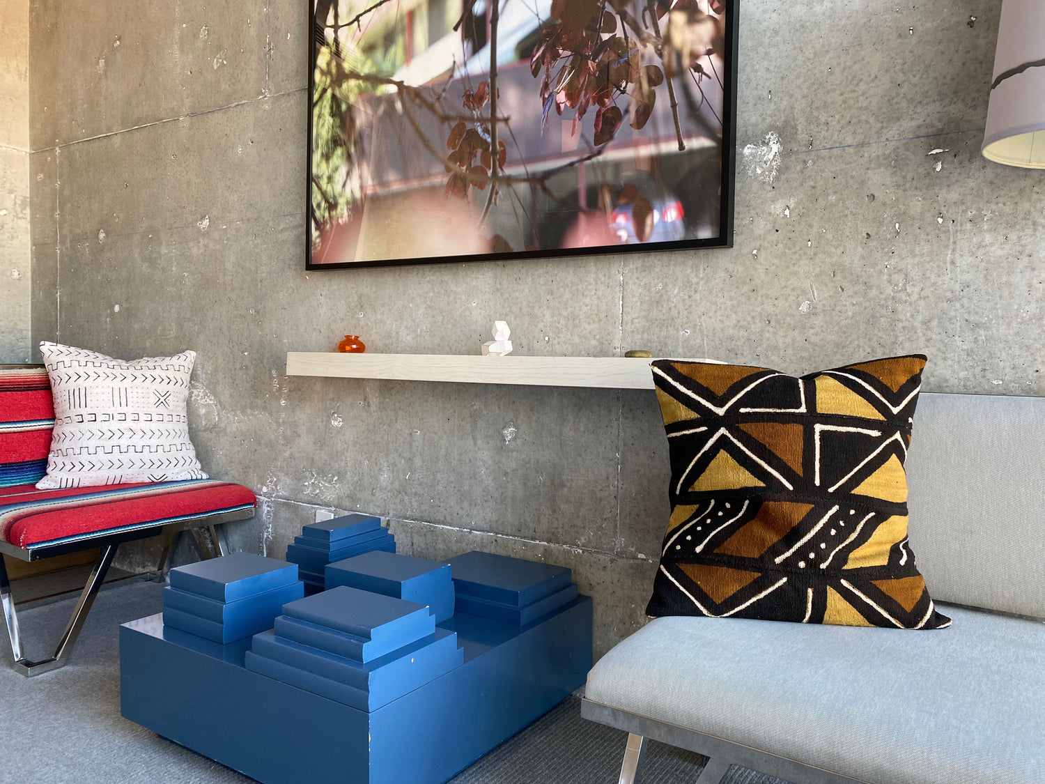 Medley of African mudcloth pillows in Sahara and bohemian inspired loft apartment. African art and kuba cloth in the background.