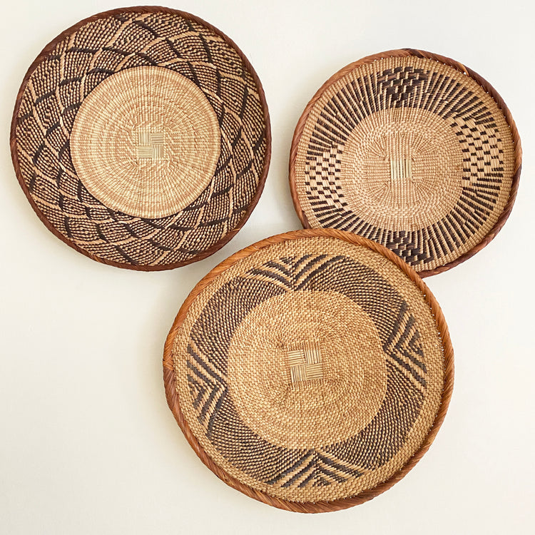 Handcrafted African baskets, Fair Trade made in Uganda and Rwanda. Decorative and African art on gallery wall with mudcloth pillows and table runner.