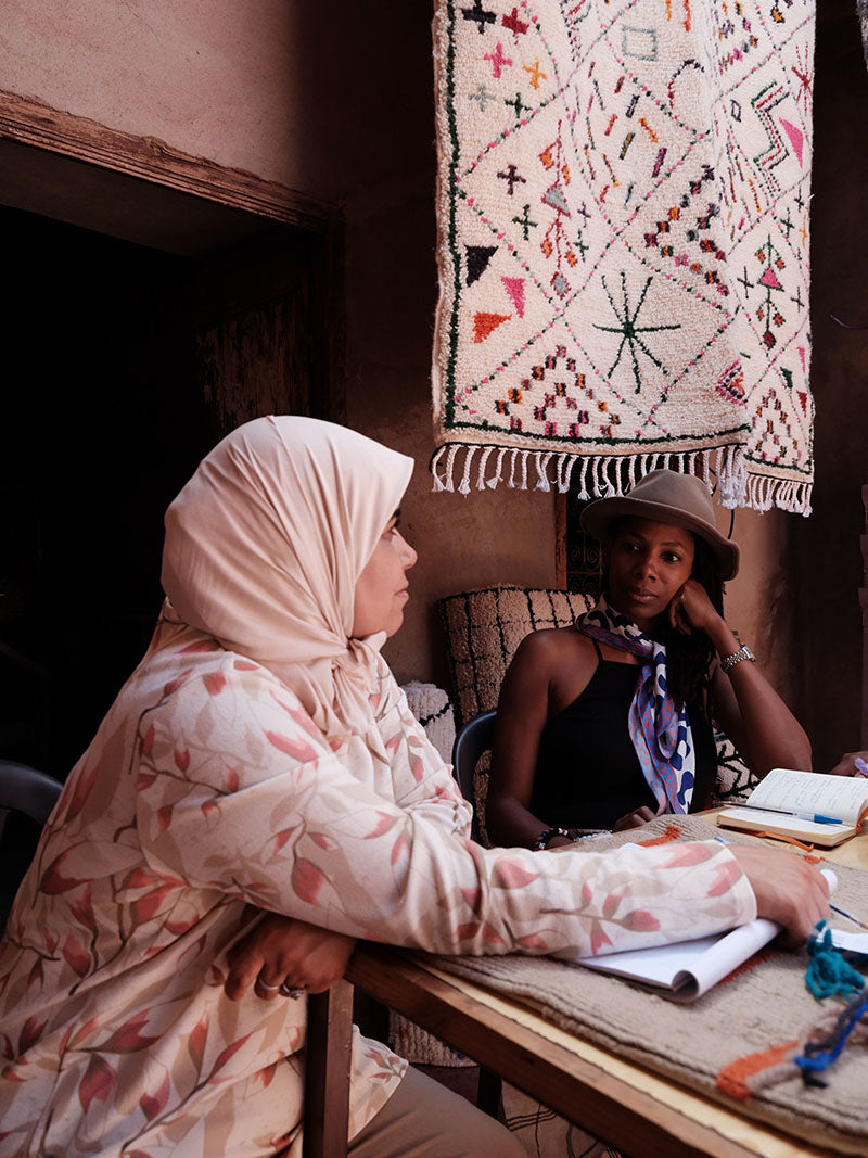 xN Studio founder Nasozi Kakembo discusses product development with ethical women's cooperative president in Morocco. This cooperative specializes in traditional Moroccan rugs, carpets, and pillows.