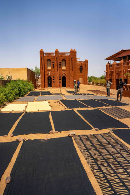 Mudcloth drying outdoors at a cooperative in Mali as seen in "The African Decor Edit"