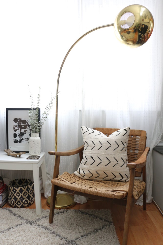 White mudcloth pillows with geometric designs styled on Danish Modern Hans Wegner Rope chair. Modern pillows made in USA, designed in Mali.