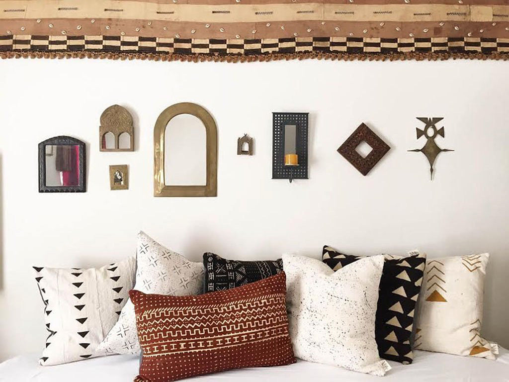 ﻿Sienna brown mudcloth pillows with minimalist geometric designs. Modern pillows made in USA, designed in Mali. Seen here with African art and Kuba cloth wall accent.