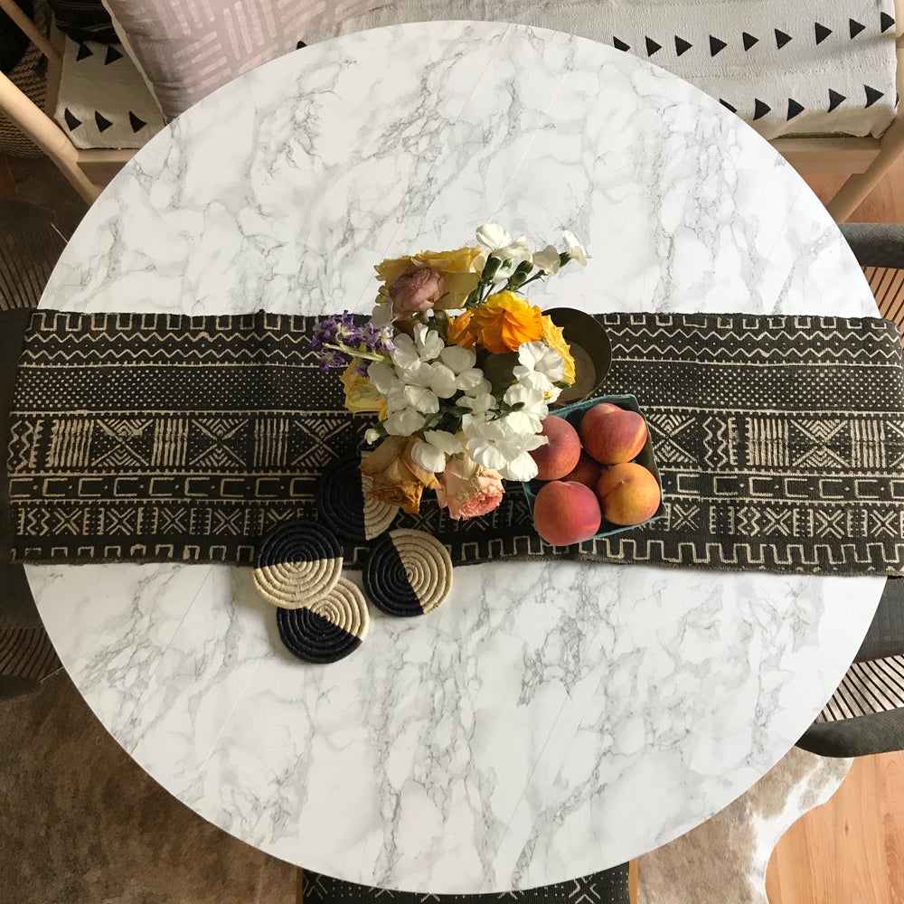 Handmade woven coasters, Fair Trade made in Uganda. Decorative and African art on table with mudcloth runner.