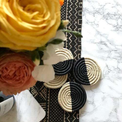 Handcrafted tableware woven coasters, Fair Tradrie made in Uganda. Decorative annd African art on table with mudcloth runner.