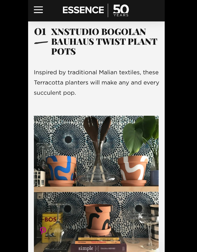 As seen on Essence.com Handpainted terracotta planters with Bauhaus bohemian painted designed. Perfect housewarming gift for herbs, succulents, and indoor house plants. African textile wallpaper in the background with open shelving and Ugandan salad servers.