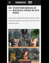Load image into Gallery viewer, As seen on Essence.com Handpainted terracotta planters with Bauhaus bohemian painted designed. Perfect housewarming gift for herbs, succulents, and indoor house plants. African textile wallpaper in the background with open shelving and Ugandan salad servers.
