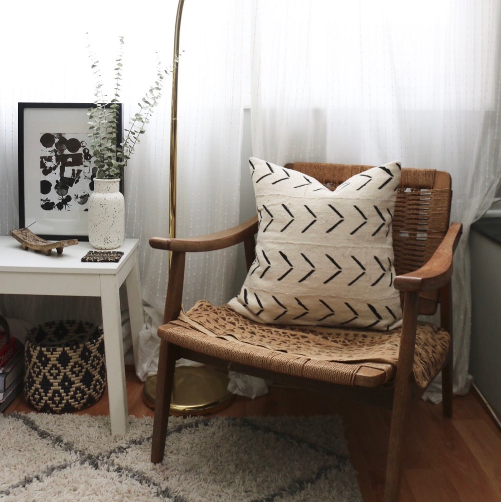 White mudcloth pillows with geometric designs styled on Danish Modern Hans Wegner Rope chair. Modern pillows made in USA, designed in Mali