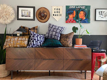 Load image into Gallery viewer, Batik textile home goods for modern Boho home, pillows made in Tanzania. Fair Trade with African art and juju hat on Danish modern credenza.

