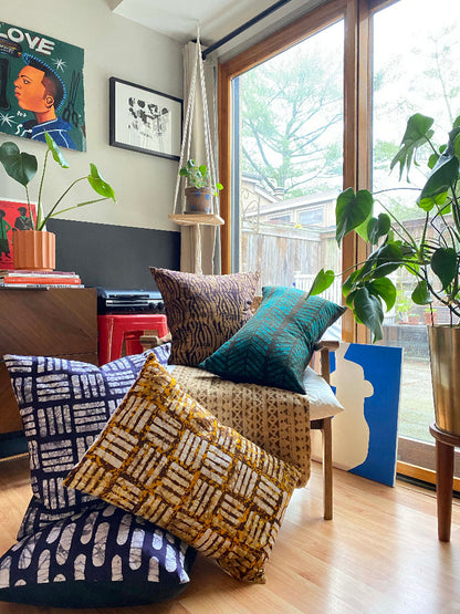 Batik and mudcloth textile home goods in modern Boho home, pillows made in Tanzania. African art.