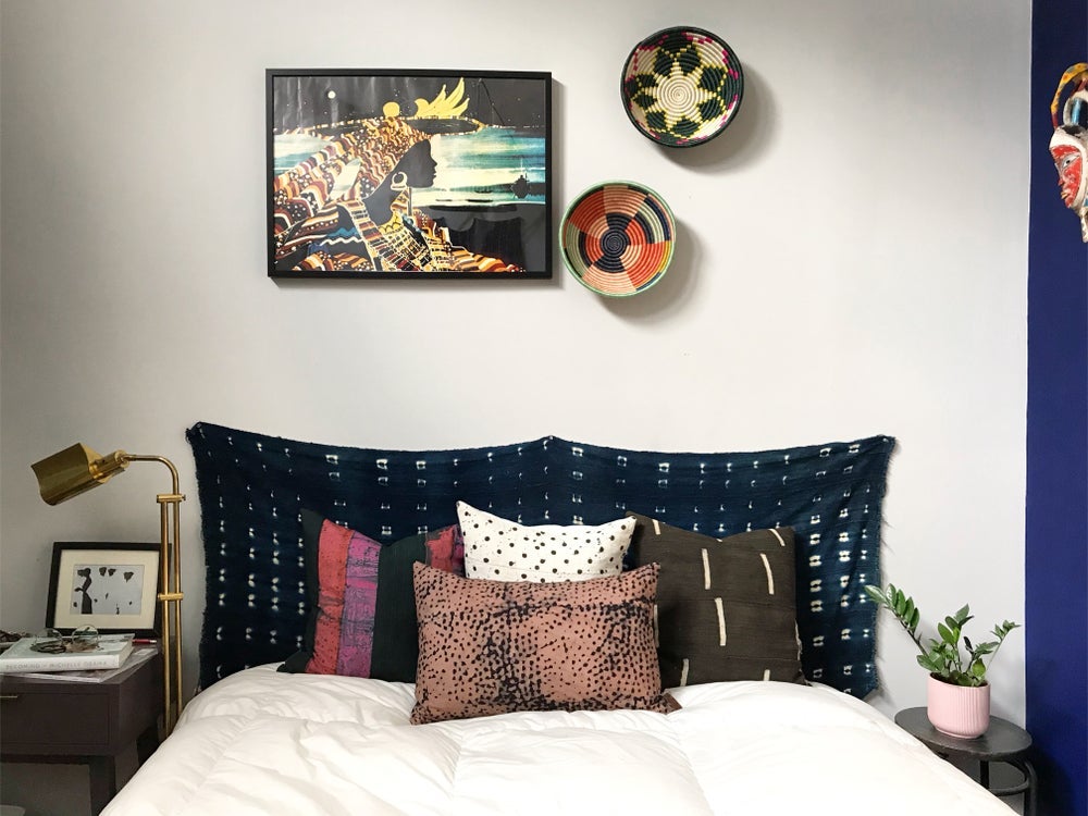 Handcrafted Black mudcloth pillows with minimalist designs styled in bedroom. Modern pillows made in USA, designed in Mali. Seen here with African art and Ugandan baskets.