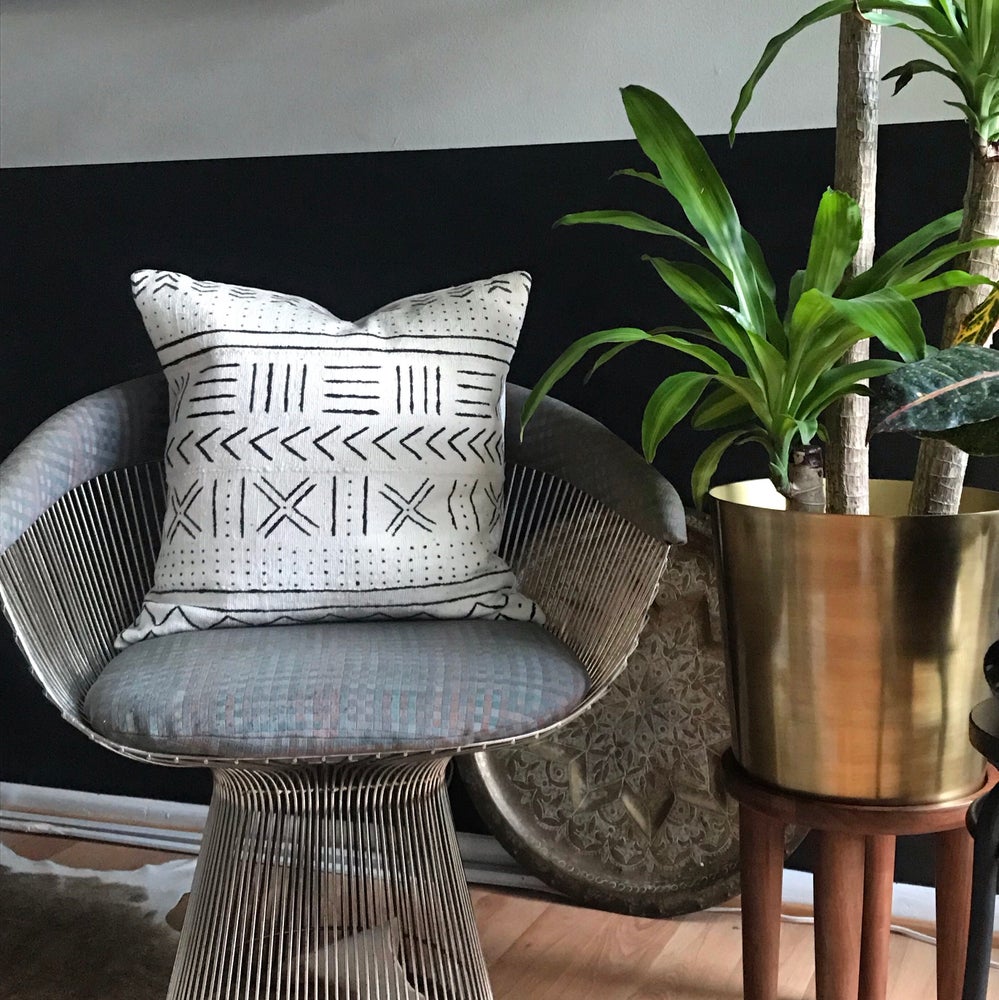 White mudcloth pillow with geometric designs styled in a Platner chair. Modern pillow made in USA, designed in Mali