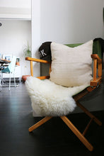 Load image into Gallery viewer, Handcrafted African mudlcoth pillow in minimalist white for modern homes. Seen in Brooklyn apartment with sheepskin.
