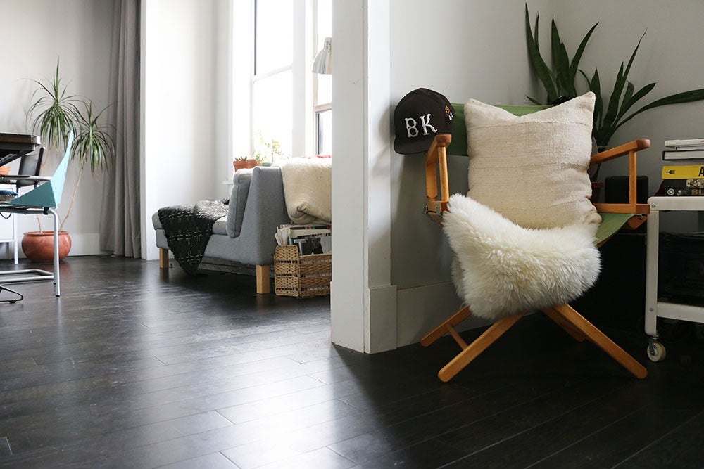 Handcrafted African mudlcoth pillow in minimalist white for modern homes. Seen in Brooklyn apartment with sheepskin.