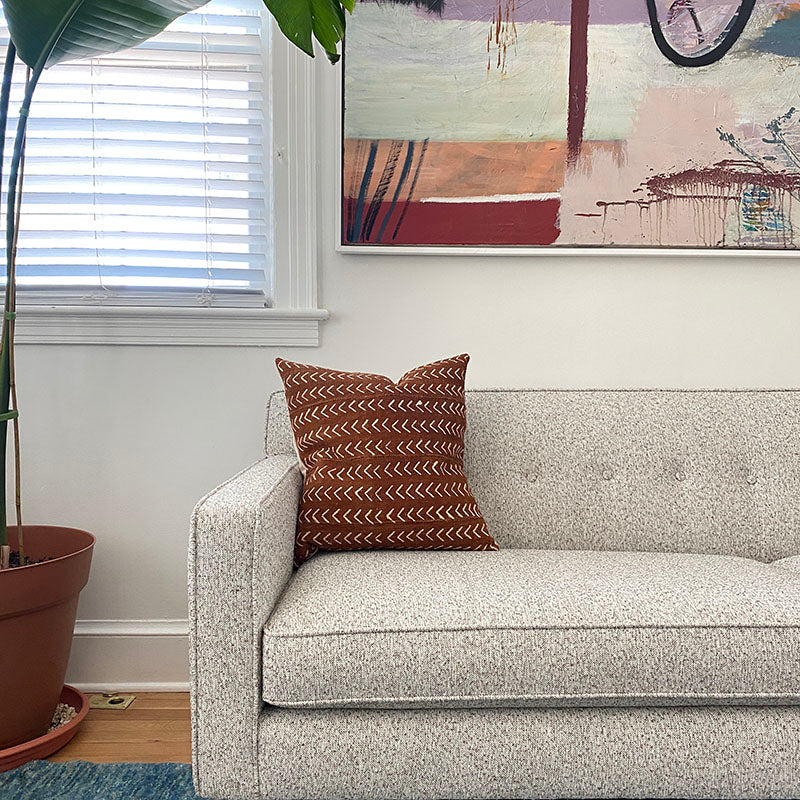 Sienna brown mudcloth pillows with minimalist geometric designs. Modern pillows made in USA, designed in Mali. Seen here with African art.