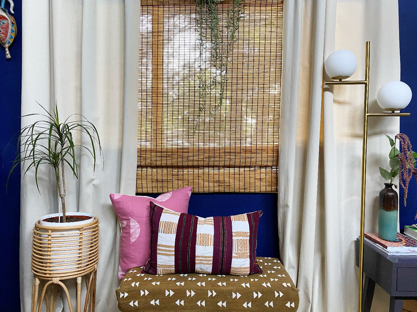 Batik and vintage asooke pillow on mudcloth bench