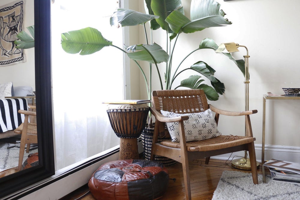 Handcrafted African mudcloth pillows with minimalist design in Black. African art and korhogo cloth in the backgroundm in Brooklyn apartment.